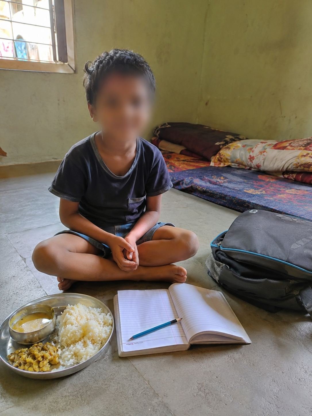 Aarav, 8, studying on the floor with his meal beside him